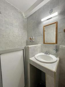 La salle de bains est pourvue d'un lavabo et d'un miroir. dans l'établissement Baja Real Hotel Boutique, à La Paz