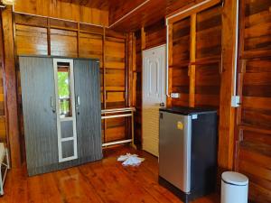 a kitchen with a refrigerator and a door in a room at Kohjum Seafront Resort in Ko Jum