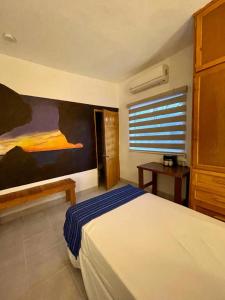 a bedroom with a bed and a window with a shutter at Baja Real Hotel Boutique in La Paz