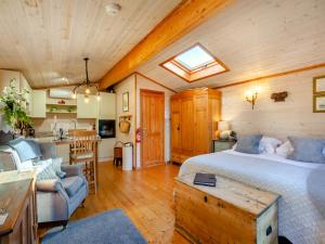 a large bedroom with a bed and a kitchen at The Lodge in Hurstpierpoint