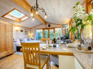 a kitchen and living room with a table and chairs at The Lodge in Hurstpierpoint