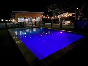 a swimming pool lit up blue at night at Sunset Cottage, Byron Bay in Ewingsdale