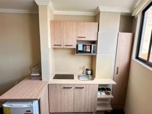 a small kitchen with a sink and a microwave at Suitesecu Cuenca in Cuenca