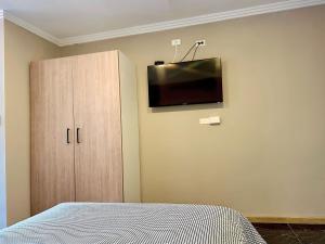 a bedroom with a bed and a tv on the wall at Suitesecu Cuenca in Cuenca