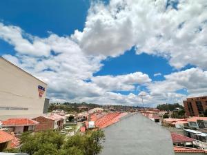 a city with buildings and a blue sky with clouds at Suitesecu Cuenca in Cuenca