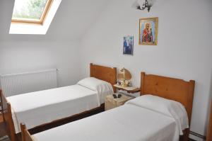 a room with two beds and a window at Pensiunea Casa Filoxenia in Horezu