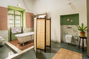 a bathroom with a tub and a toilet at Casa Desa Monteiro 4BHK Stand Alone Villa In Diwar Island with Complementary Breakfast & Private Pool, Garden, Fully Equipped Kitchen in Divar +25 photos
