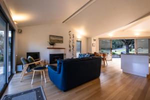 a living room with a blue couch and a table at Driftwood in Coles Bay