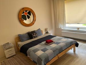 1 dormitorio con 1 cama con reloj en la pared en Cosy house in Center of Tartu, en Tartu