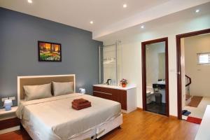 um quarto com uma cama e uma casa de banho com um lavatório em May - FABULOUS - Phone 09756-59323 em Hanói