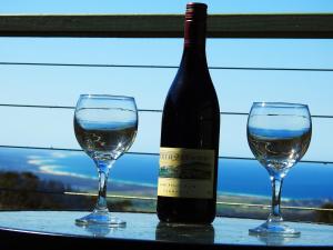 Una botella de vino y dos copas en una mesa. en Lumera Eco Chalets, en Saint Marys