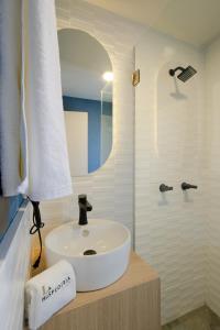 uma casa de banho com um lavatório branco e um espelho. em La Hospedería León em León