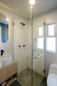 uma casa de banho com uma cabina de duche em vidro e um lavatório. em La Hospedería León em León