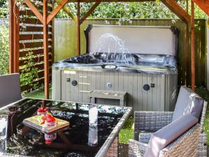 a hot tub in a backyard with a fountain at Old Toads Barn in Theddlethorpe Saint Helen