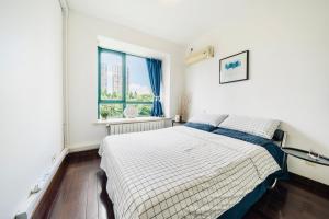 1 dormitorio con cama y ventana en Shanghai New International Expo Center Hanzhiju Apartment en Shanghái