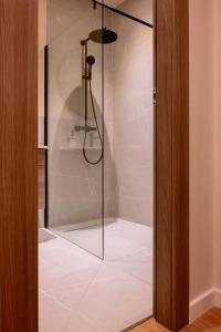 a shower with a glass door in a bathroom at La Boheme Corbeanca - partener Therme in Ostratu