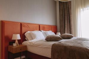 a bedroom with a bed with two pillows on it at La Boheme Corbeanca - partener Therme in Ostratu
