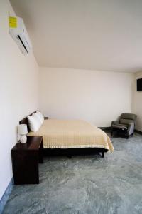 ein Schlafzimmer mit einem Bett und einem Sofa in einem Zimmer in der Unterkunft HOTEL & RV PARK ROSA EVELYN in San Quintín
