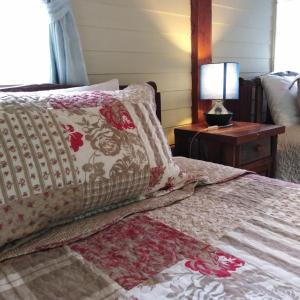 łóżko z poduszką i lampą na stole w obiekcie At Home Chiang Dao, Pooch Lovers w mieście Ban Tham