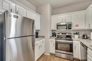 a kitchen with white cabinets and a stainless steel refrigerator at 2 Jumbo King Beds w Pool 4K TVs Close to Hill AFB in Clearfield