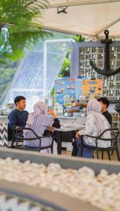 a group of people sitting at a table in a restaurant at Kapal Garden Hotel at Rekreasi Sengkaling in Malang