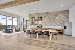 a kitchen with a table and chairs and a refrigerator at Brand New Lux Apartment - Year Round Pool - HAFB in Clearfield