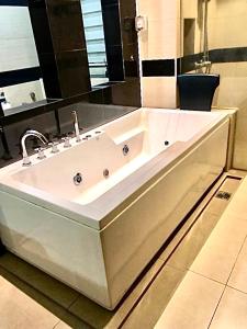 a large white bath tub in a bathroom at Luxurious Villa with BBQ & JACUZZI By The Beach Batu Ferringhi in Batu Ferringhi