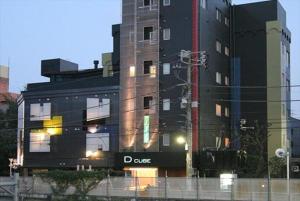 un gran edificio negro con un cartel aturdido en él en HOTEL DCUBE en Tokio