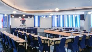 a conference room with tables and chairs and a whiteboard at Kapal Garden Hotel at Rekreasi Sengkaling in Malang +95 photos