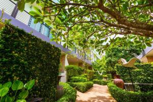 un edificio con un jardín con arbustos y árboles en Baan Noppadol Hua Hin Resort, en Hua Hin