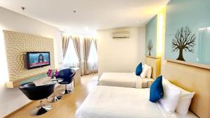 pokój hotelowy z dwoma łóżkami i telewizorem w obiekcie Holiday Place Kuala Lumpur w Kuala Lumpur