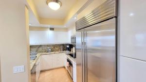 a kitchen with a stainless steel refrigerator at Habor Club Gaslamp Quarter 30-Day Min in San Diego