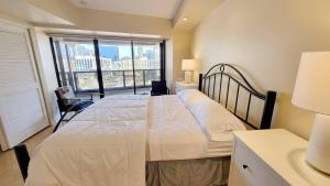 a bedroom with a bed and a large window at Habor Club Gaslamp Quarter 30-Day Min in San Diego