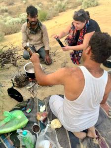 een groep mensen die rond een kampvuur zitten bij Martine guest house in Jaisalmer