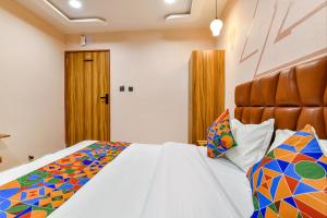 um quarto com uma cama grande e um edredão colorido em FabHotel The Palace em Vadodara