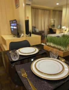 una mesa con platos y tenedores y una sala de estar. en Studio Suite beside Greenbelt Mall Makati City, en Manila