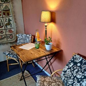 een tafel met een lamp en een plant erop bij Carmen's Stay In - Jaagweg 13 Ilpendam in Ilpendam