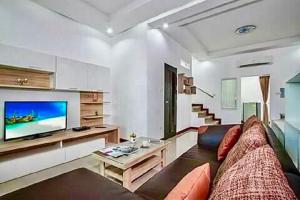 sala de estar con sofá y TV de pantalla plana en Baan Noppadol Hua Hin Resort, en Hua Hin