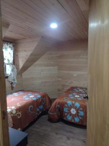 Habitación con 2 camas en una cabaña de madera en Cabañas San Francisco, 