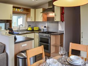 a kitchen with a dining table and a kitchen with yellow cabinets at Slaters - Uk44967 in Plumbland