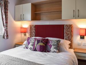 a bedroom with a bed with a red headboard and pillows at Slaters - Uk44967 in Plumbland