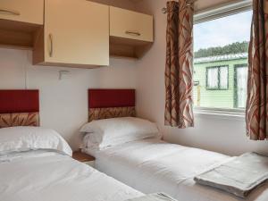 two beds in a small room with a window at Slaters - Uk44967 in Plumbland