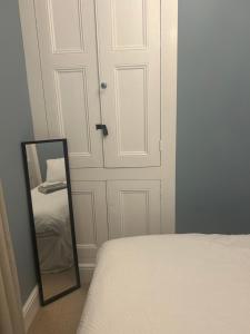 a bedroom with a mirror next to a door at Choristers Mews: Luxury cottage a stones throw from the Cathedral! in Lincolnshire