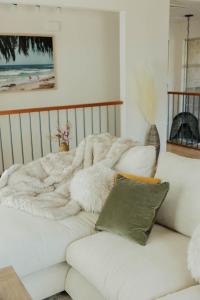 Gorgeous Designer Home In Pb - Walk To Bay&beach في سان دييغو: غرفة معيشة مع أريكة بيضاء وبطانية