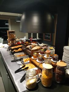 una línea de buffet con muchos tipos diferentes de comida en Campanile Pont-à-Mousson, en Pont-à-Mousson