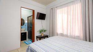 1 dormitorio con cama, espejo y TV en Casa Las Tres Marias, en Fortuna