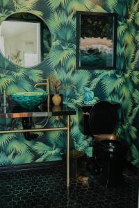 uma casa de banho com um papel de parede verde e um lavatório em Dreamy Pb Home - Walk To Bay And Beach em San Diego
