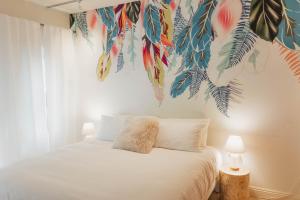 um quarto com uma cama com um mural tropical na parede em Dreamy Pb Home - Walk To Bay And Beach em San Diego