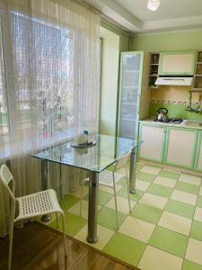 a kitchen with a glass table in a kitchen at Юбилейный in Almaty