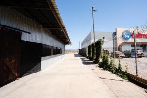 einen Gehweg neben einem Gebäude mit einem Zaun in der Unterkunft HOTEL & RV PARK ROSA EVELYN in San Quintín